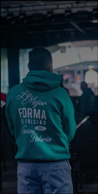 Asistente con la casaca de Universidad de la Vida, de espaldas